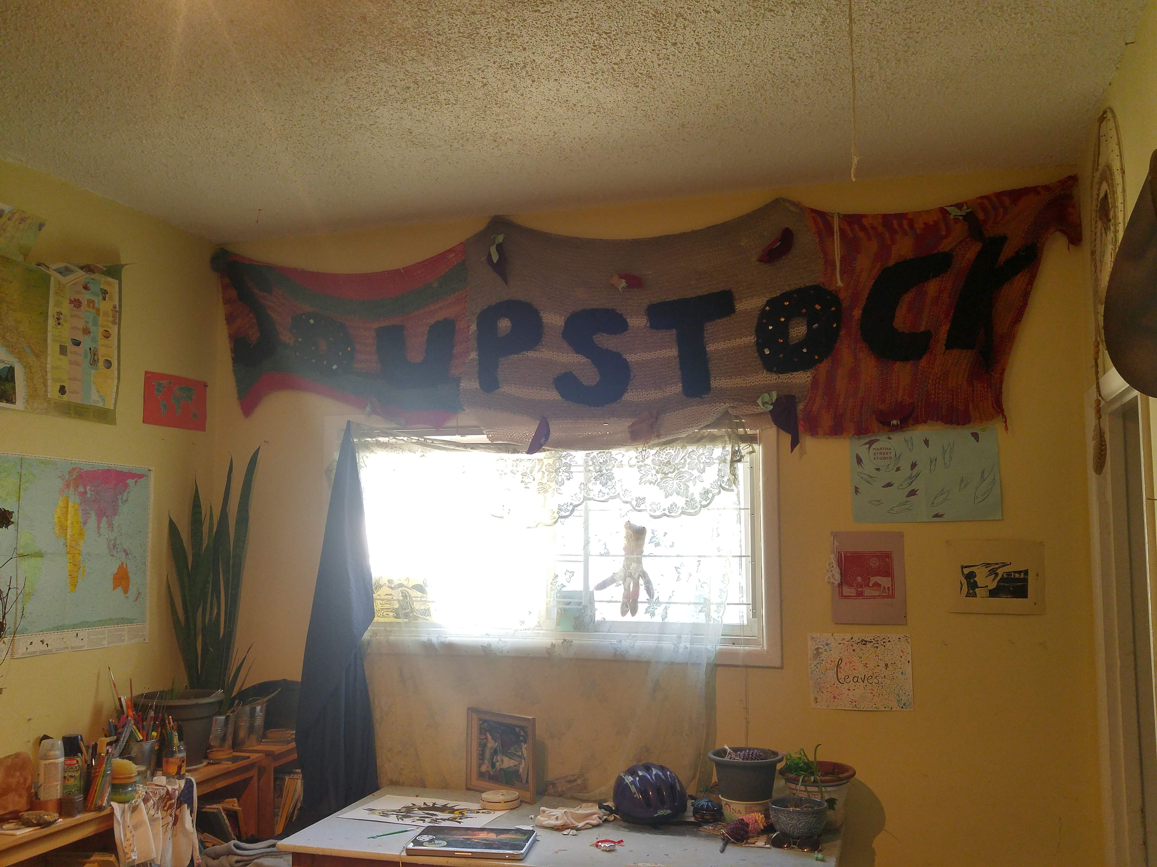 A giant knitted banner saying soupstock, over the livingroom window