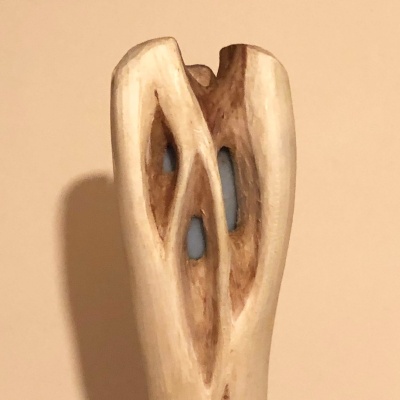 The head of a staff, white with crosscrossing branchwork pattern carved out to hold a light blue Angelite stone, visible inside the branchwork