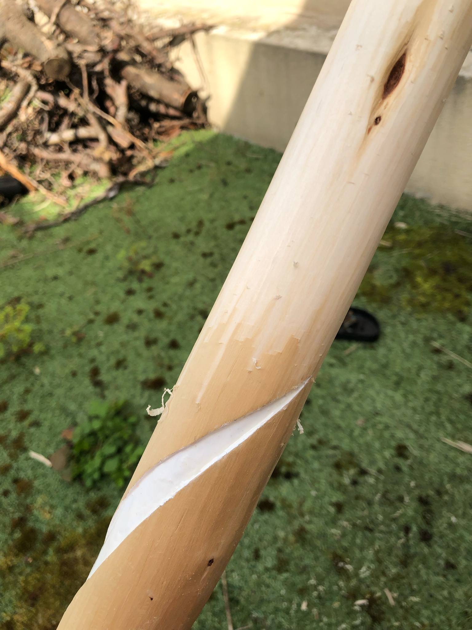 The side of the staff having its surface scraped clean again, removing the older, oxidized