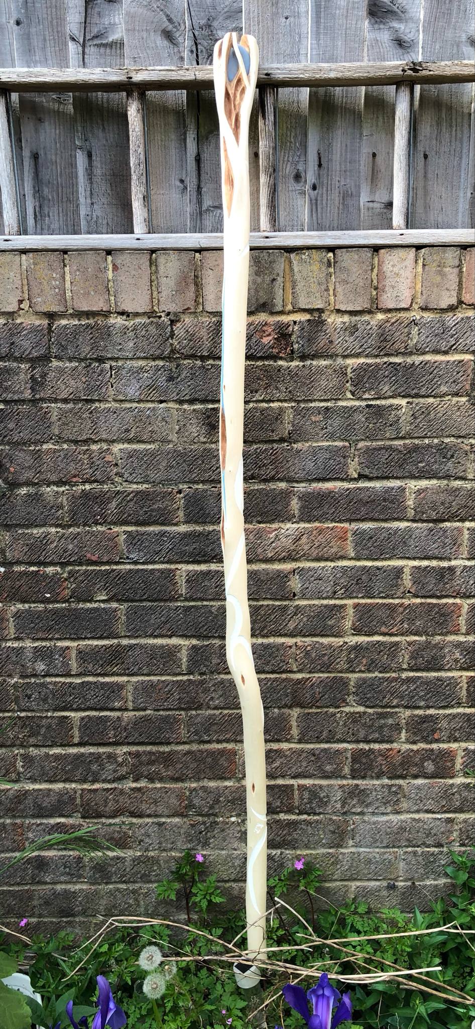 The back of the staff, showing the light blue line filling in the crack, and the back of the head which has an even more intricate weave of branches wrapping around the stone.