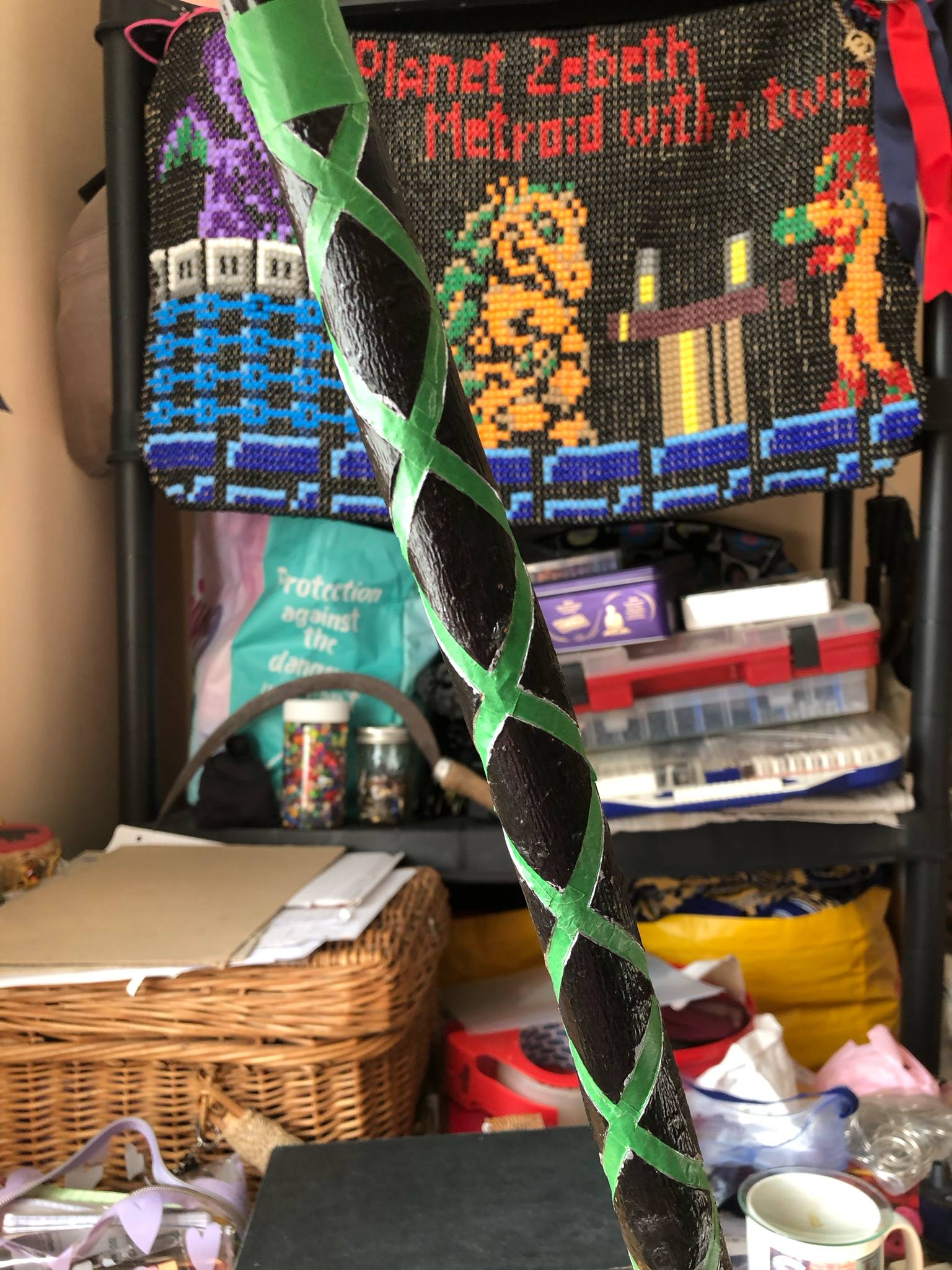 A photo of the staff, with all of the lines for the bottom half of the staff filled in with green painters tape.