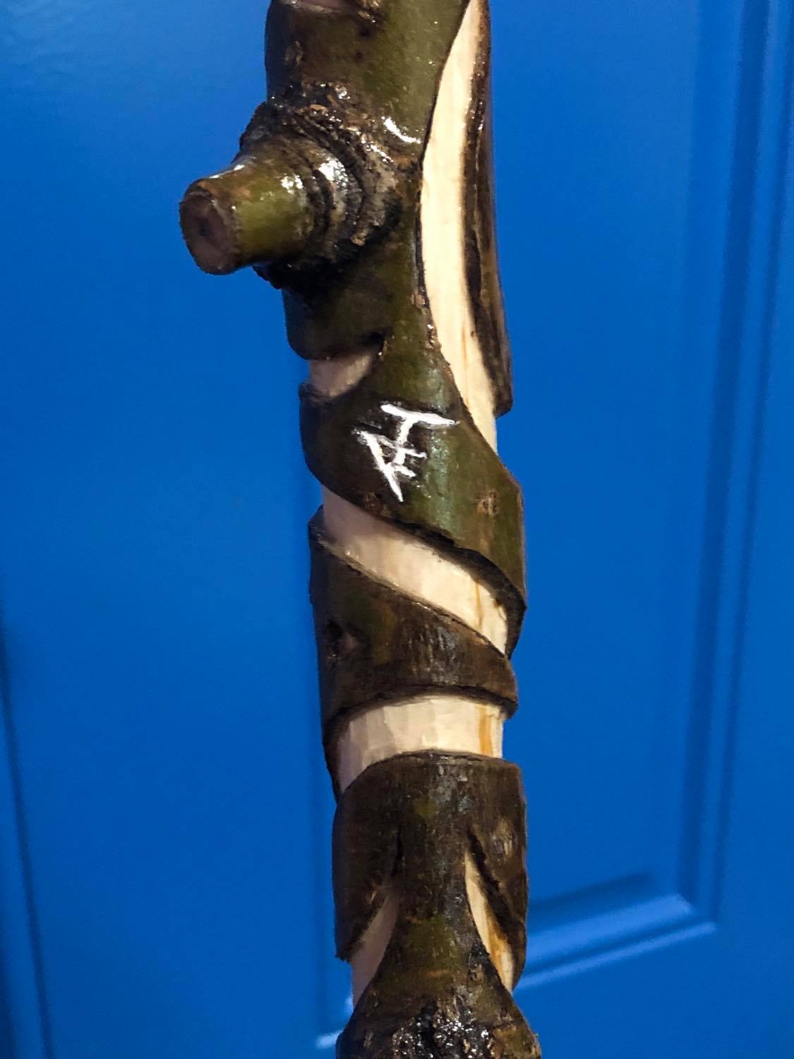 Showing one of the tiny symbols carved into the side and painted black or white, this one is white, all red herrings.