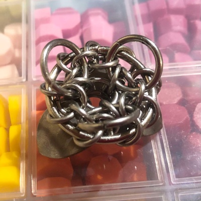A small, circular stand made up from stainless steel scales and different sized rings.