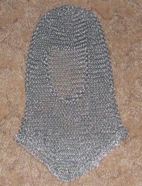 The coif laying flat on the ground, on a light brown carpet.