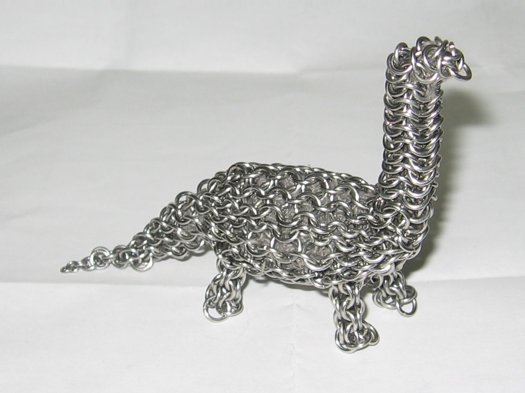 The dinosaur on a white paper surface, all the legs sturdy and neck straight.