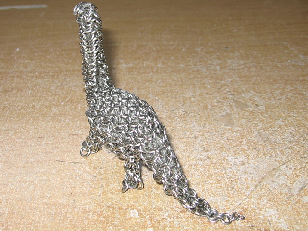 The dinosaur walking away, showing the back and tail of the dinosaur off.
