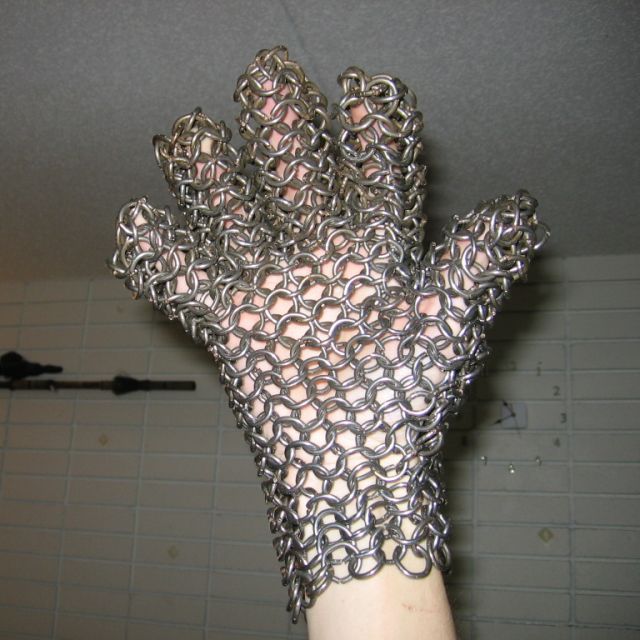 Kabutroid wearing the chainmaille glove, making her fingers twice as thick, and holding it in the air.