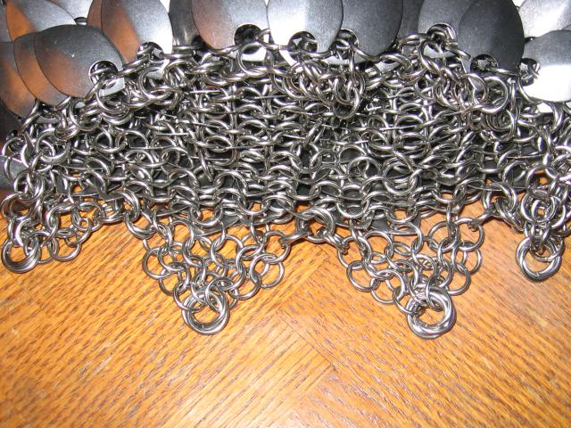 A closeup of the top of the purse, where sections of the circumfrence come together into points, ending with a three-ring mobius ball for strength.