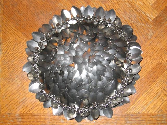 The purse creatively clumped to show the sealed bottom, and it partially folded inside out to have some scales splay out around the outside.