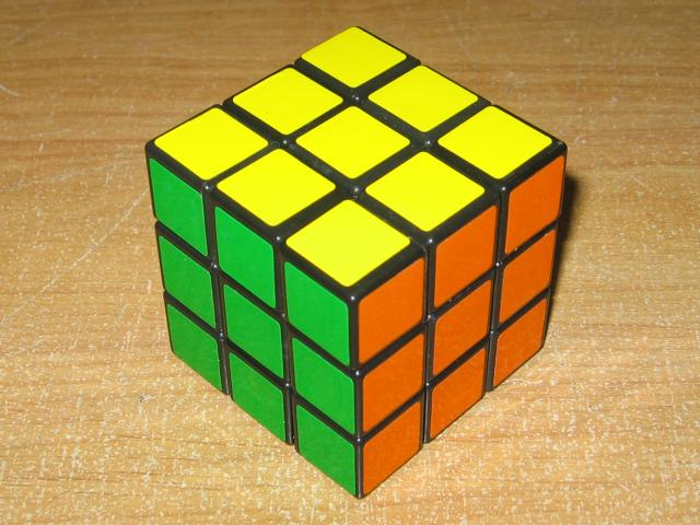 A Rubik's cube on a wooden table.