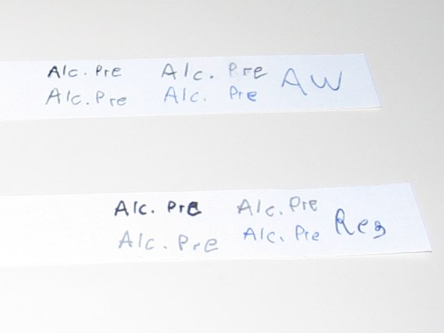 The two papers one above the other, all weather on top and regular beneath. The writing appears nearly identical when dry.
