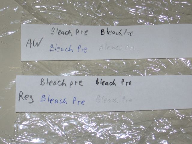 The regular and all weather test strips, with bleach pre written on them, laying on plastic wrap.