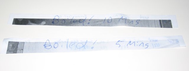 Two strips of paper, with boiled! 5 minutes written on them. They appear very similar.