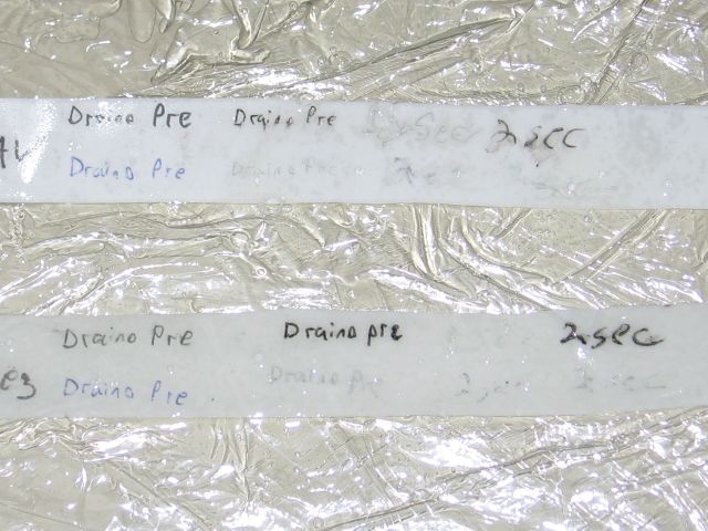 The two strips of paper, with the regular soaked mostly through, and the all weather paper looking wetter as well.