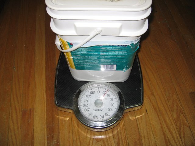 A large bucket sitting on top of a weigh scale.