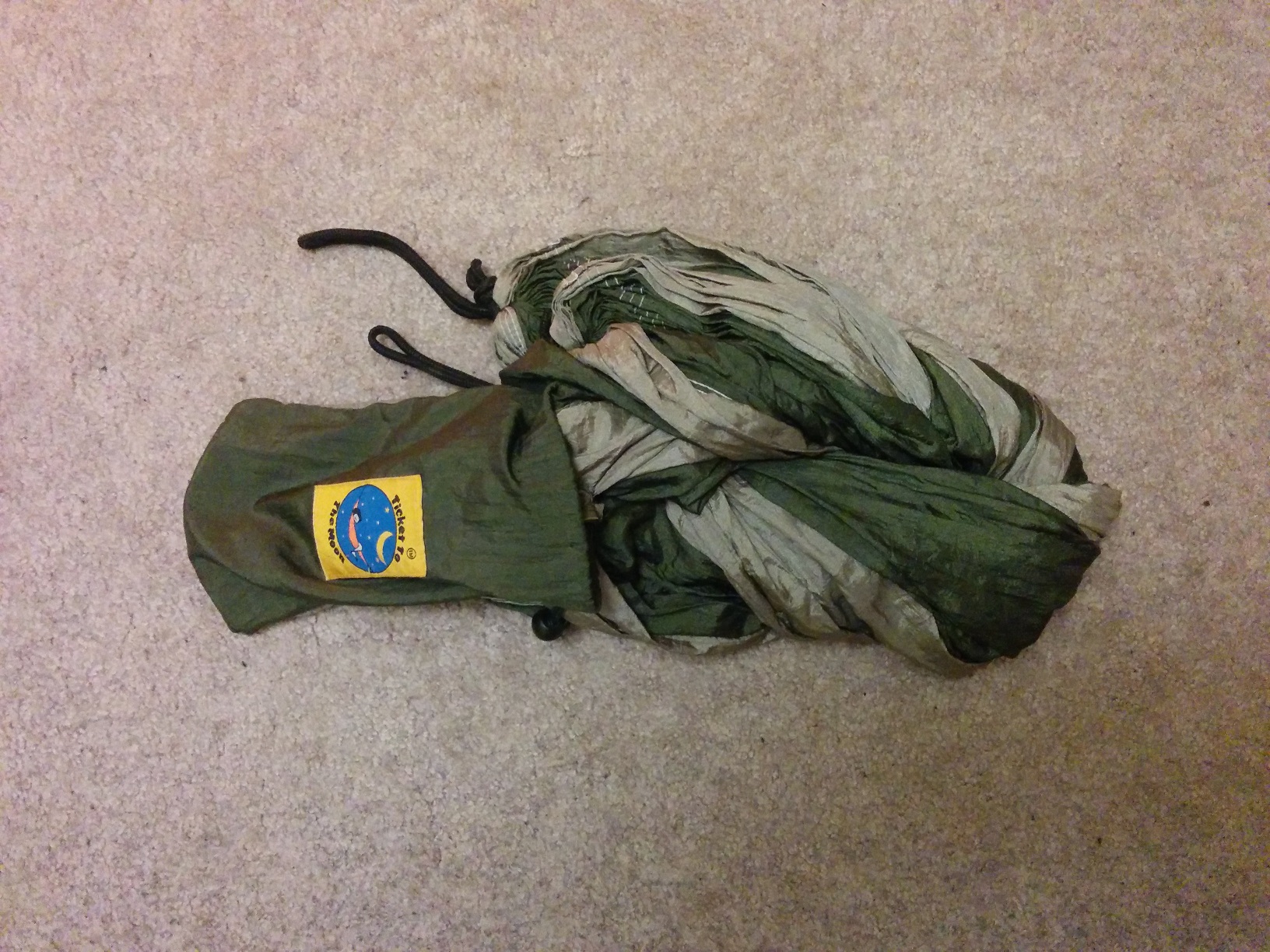 The fabric half-packed into the pouch, which was at one end of the bundle, all still on that offwhite carpet.