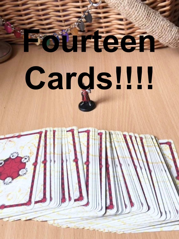 The Raven video where fourteen cards are drawn for the adventurer! The image is of a painted fighter mini looing at the spread out harrow deck of many things in front of it on a wooden table.