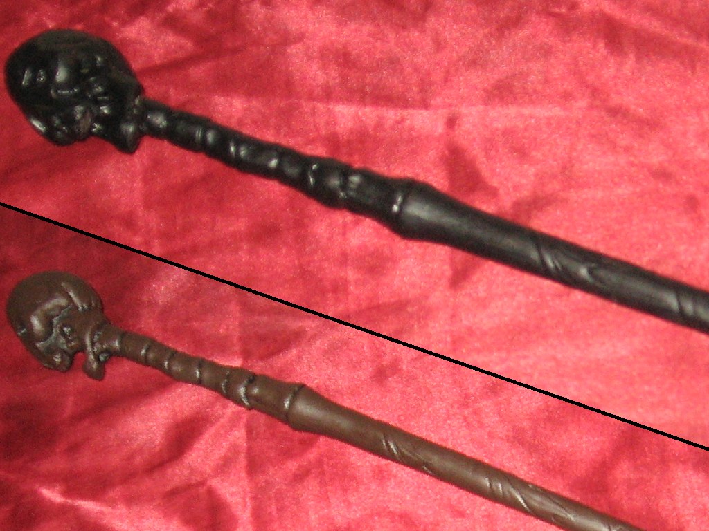Showing the wand on the fabric, first with it primer black, and then with it painted brown overtop.