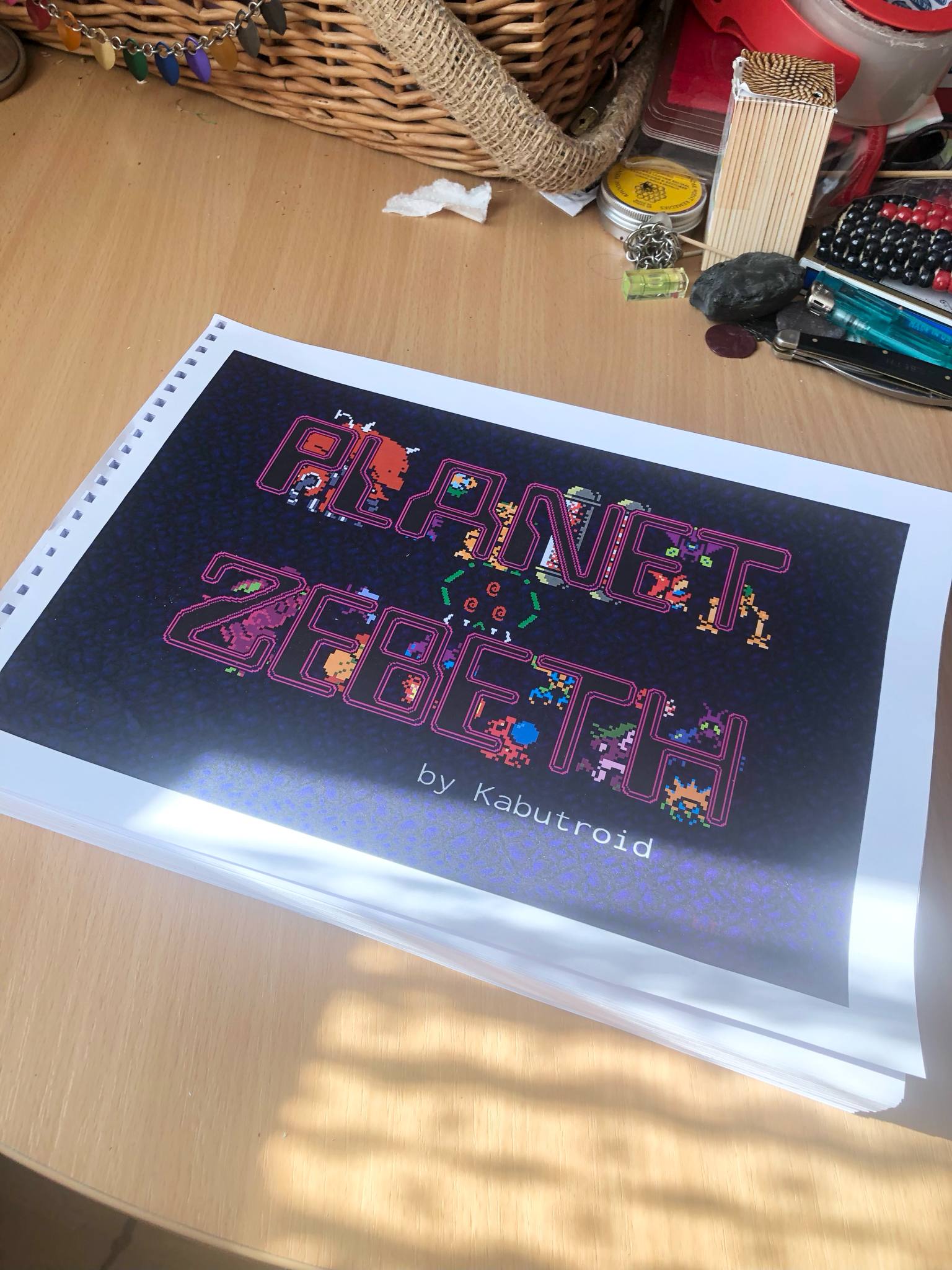 Planet Zebeth, the printout of the entire comic at nearly three centimeters thick, sitting on a table and bound by metal binding rings. Link goes to the main printed Zebeth page.