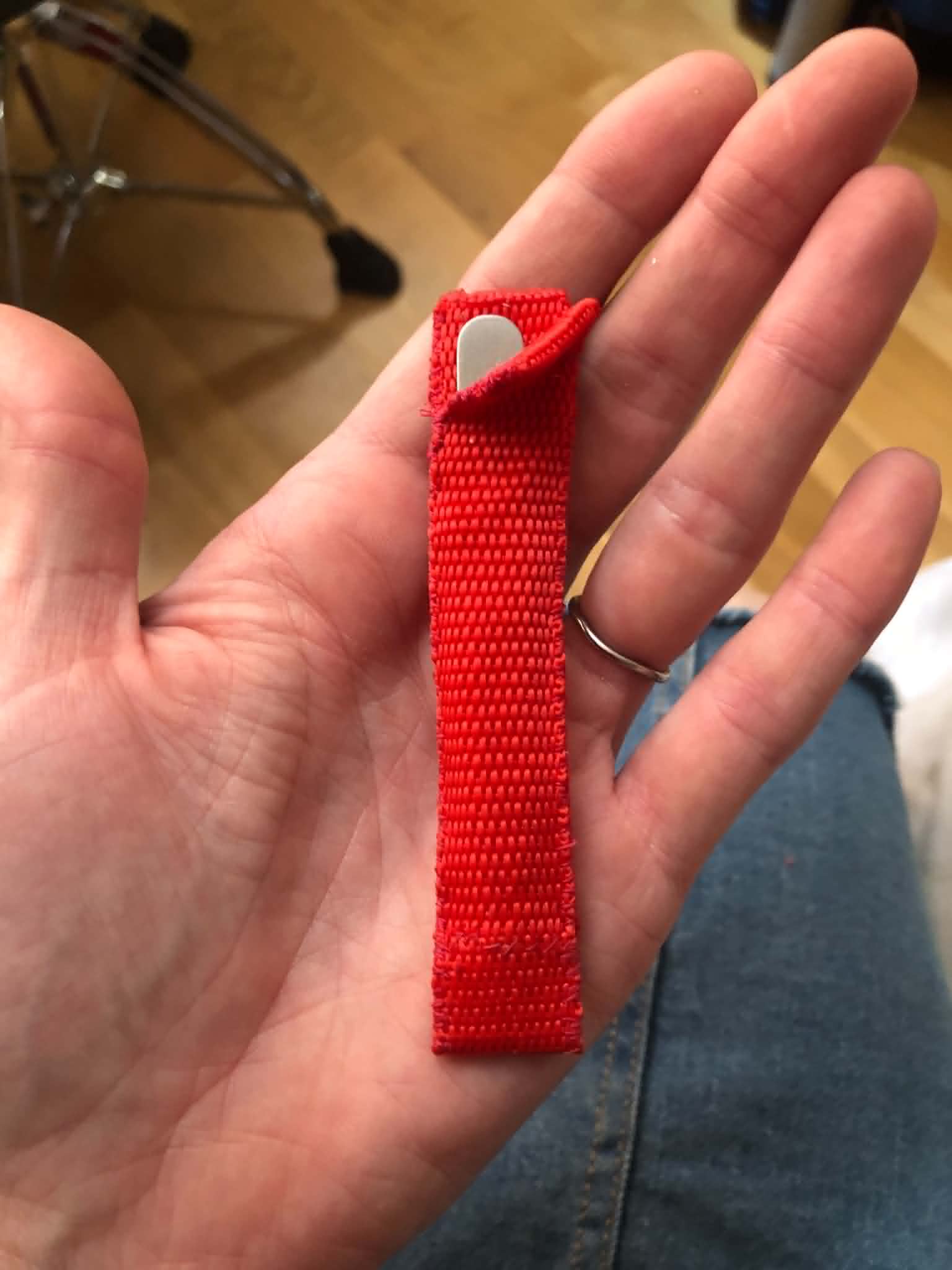 A tweezers case made from a red nylon strap.