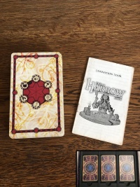 The Harrow deck cards and instruction manual beside, on a wooden desk.