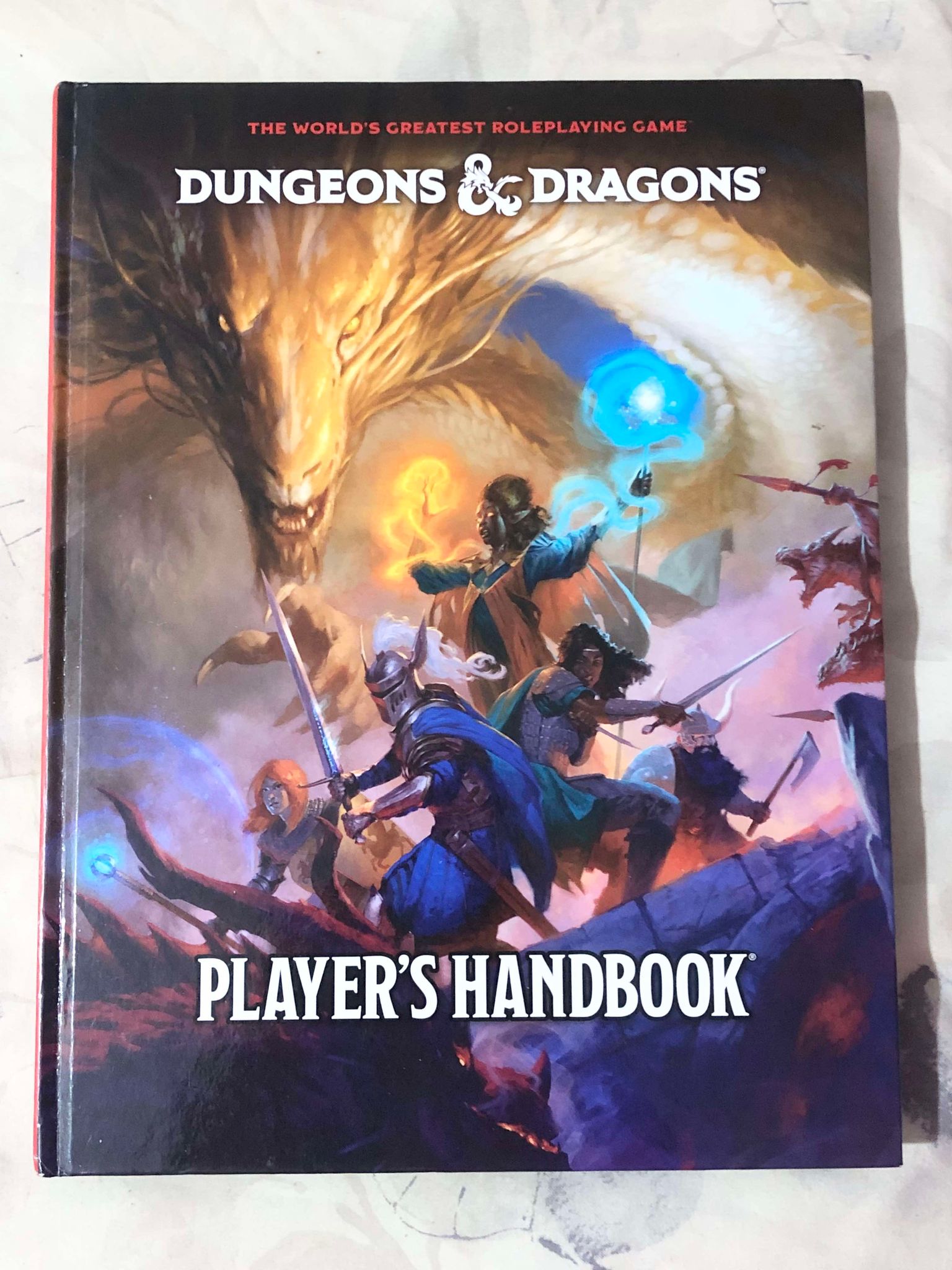 The 2024 Player's Handbook, depicting a party of fighters and magic users with a giant golden dragon behind them, seemingly an ally of the group.