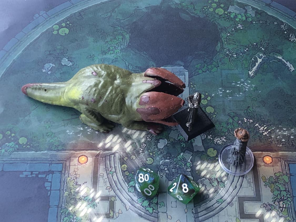 The battle map from above, with the monk fully attacking the creature, and the sorcerer rolling a pair of d10 dice to determine the wild magic surge.